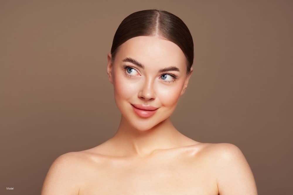 Young woman smiling and looking to the side.